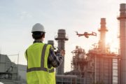 Asian construction worker piloting drone at building site. video surveillance or industrial inspection